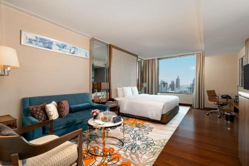 a hotel room with a bed and a couch at Radisson Blu Plaza Bangkok in Bangkok