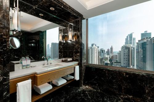 a bathroom with a sink and a large window at Radisson Blu Plaza Bangkok in Bangkok
