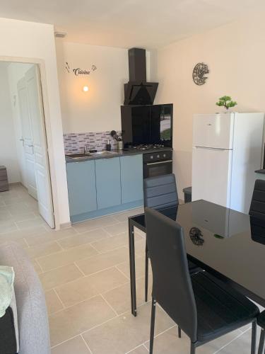 une cuisine avec une table et un réfrigérateur blanc dans l'établissement gîte, à Molières