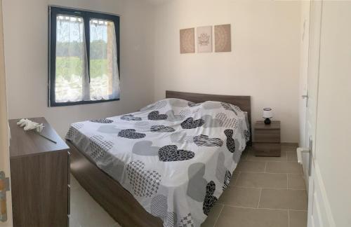 une chambre avec un lit avec une couette noire et blanche dans l'établissement gîte, à Molières