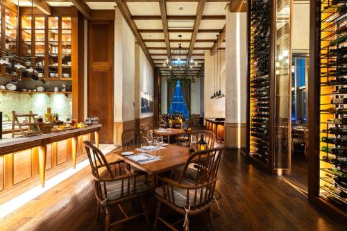 a dining room with a table and chairs and wine racks at Radisson Blu Plaza Bangkok in Bangkok