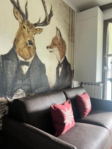 ein Wandbild von zwei Hirschen in Anzügen an einer Wand in der Unterkunft Mandi Mandi con vista in Tarvis