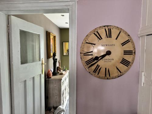 a large clock on a wall in a hallway at Beautiful three bedroom house in Liverpool
