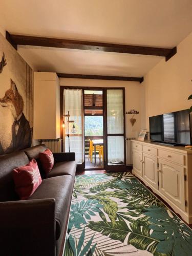 ein Wohnzimmer mit Couch und Flachbildfernseher in der Unterkunft Mandi Mandi con vista in Tarvis