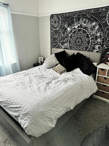 a bedroom with a bed with a black and white comforter at Beautiful three bedroom house in Liverpool