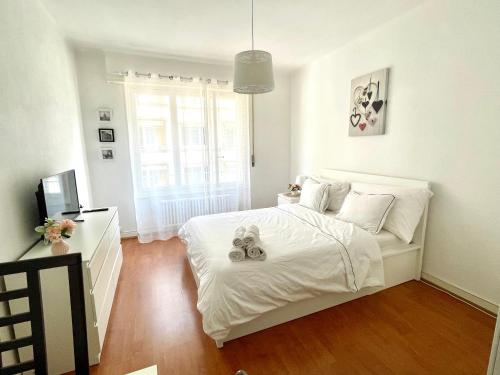 a bedroom with a white bed with two stuffed animals on it at 2 minutes- 200m de la Gare de Lausanne in Lausanne