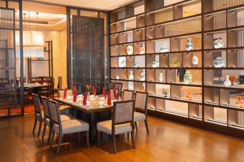 a dining room with a table and chairs and shelves at Radisson Blu Plaza Bangkok in Bangkok