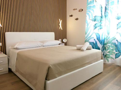 iLbacioDelSole في جيتا: غرفة نوم بسرير ابيض وبجدار مخطط