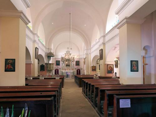 a large church with wooden pews and a chandelier at Apartmán Hortenzie in Mařenice