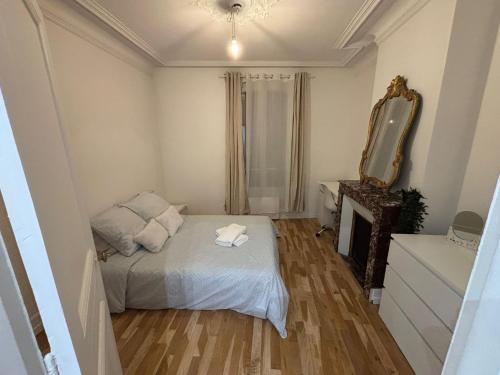 une petite chambre avec un lit et un miroir dans l'établissement Appartement cosy, à Ivry-sur-Seine