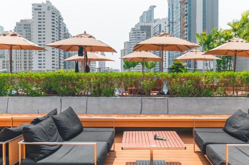 a patio with couches and tables and umbrellas at Radisson Blu Plaza Bangkok in Bangkok