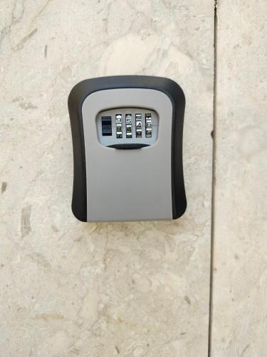a black and white soap dispenser on a wall at شقق الشريفة in Al Madinah