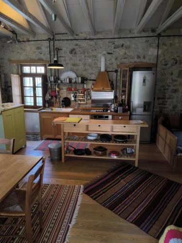 a kitchen with a table and a refrigerator at The Mountain House -mountain getaway in Sirako