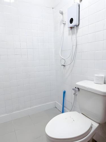 a white bathroom with a toilet and a shower at XX Toss Inn Hat Yai - ทอส อิน หาดใหญ่ in Hat Yai