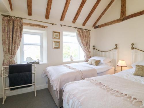 a bedroom with two beds and a window at Rose Cottage in Buxton