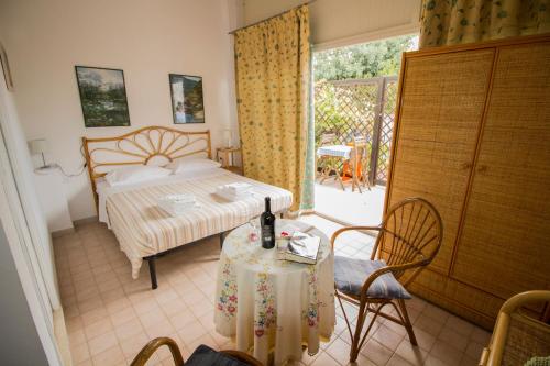 a bedroom with a bed and a table and chairs at Noto Sole di Sicilia in Noto Marina