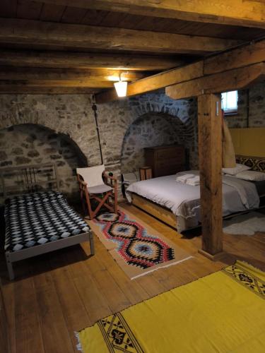 a bedroom with a bed and a chair in a building at The Mountain House -mountain getaway in Sirako