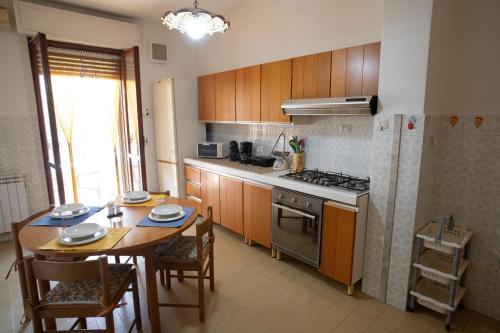 a kitchen with a table and a stove and a table and chairs at Cullati dal Mare Apartments in Pozzallo