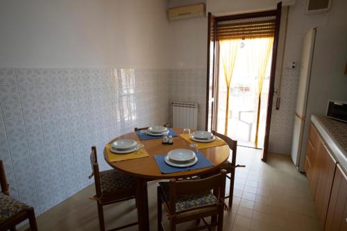 a dining room table and chairs with a table and a window at Cullati dal Mare Apartments in Pozzallo