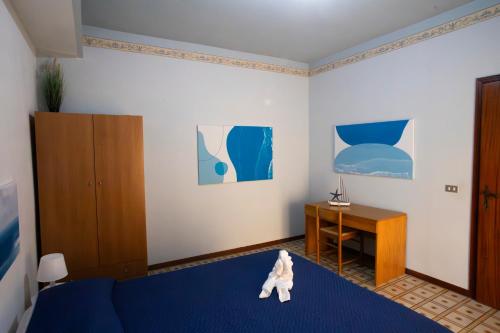 a teddy bear sitting on a bed in a bedroom at Cullati dal Mare Apartments in Pozzallo