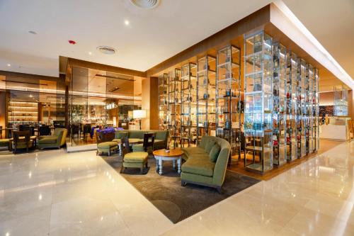 a lobby with chairs and tables and wine bottles at Radisson Blu Plaza Bangkok in Bangkok