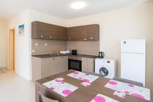 a kitchen with a table with pink decorations on it at Star Dreams Apartment with Glass Veranda in Sveti Vlas