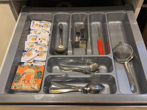 a tray with silver utensils in a sink at square residency in Ghaziabad