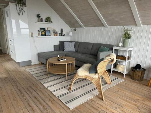 a living room with a couch and a table at Cozy cottage with sea view in Esbjerg