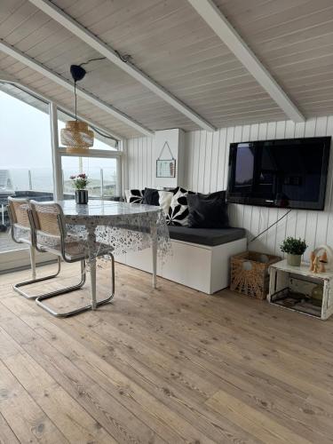 a living room with a table and a couch at Cozy cottage with sea view in Esbjerg