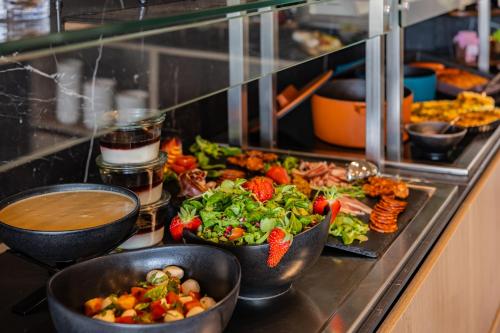 a buffet line with bowls of vegetables and other food at Viale Boutique Hotel in Villány