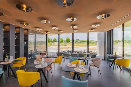 a restaurant with tables and chairs and windows at Viale Boutique Hotel in Villány