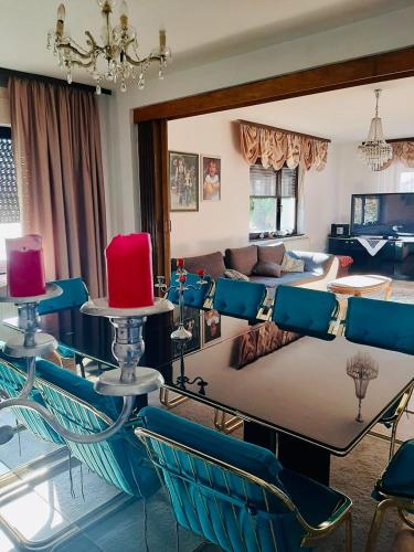a living room with a table and blue chairs at Vila Nina 