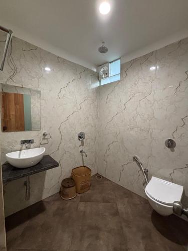 a bathroom with a sink and a toilet at Hotel Petal Inn in Nagpur