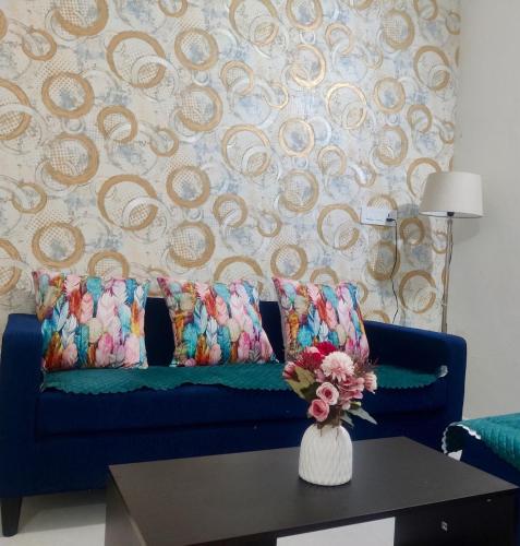 a blue couch in a living room with a table at Elegance Beyond Ordinary Stays in Zirakpur
