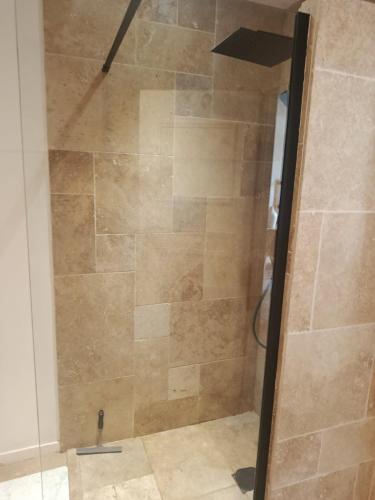 une douche avec une porte vitrée dans une salle de bain dans l'établissement Fabuleuse maison 3 chambres avec piscine entre Bordeaux et saint Emilion, à Sadirac