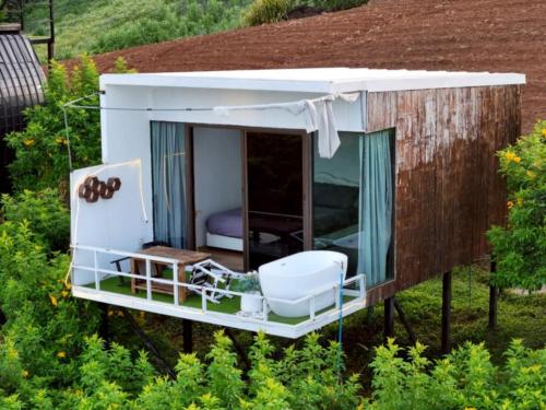 a tiny house with a bed and a room at ดอกฟ้า ม่อนแจ่ม in Mon Jam