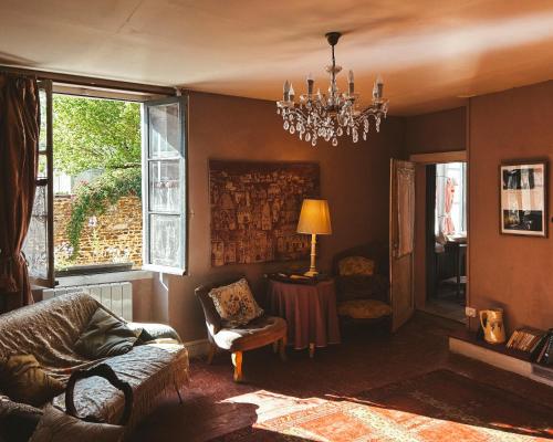 - un salon avec un canapé et un lustre dans l'établissement Darlings Guest House, à Saint-Sauveur-en-Puisaye