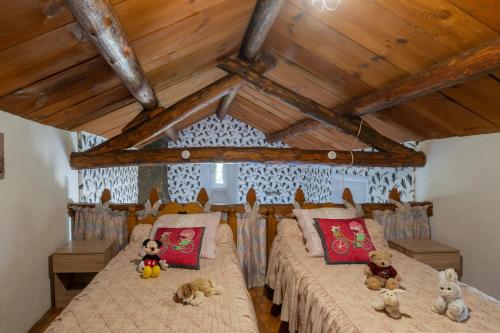 1 dormitorio con 2 camas con animales de peluche en Les Gîtes du Mas Lachamp, en Gravières