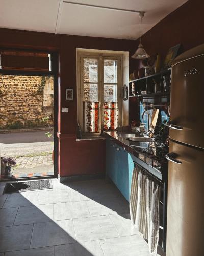 une cuisine avec un évier et un réfrigérateur dans l'établissement Darlings Guest House, à Saint-Sauveur-en-Puisaye