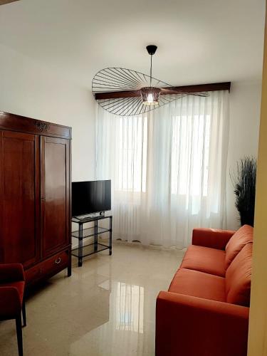 a living room with a red couch and a tv at Foresteria Juvarra in Mantova