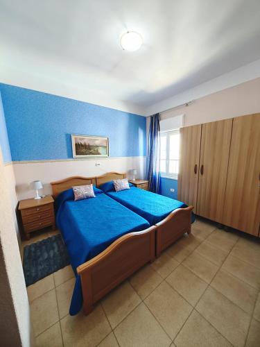 a bedroom with a large bed with blue walls at Valparadiso Apartment in Naro
