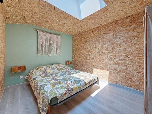 une chambre avec un lit et un mur en pierre dans l'établissement Bienvenue à l'Atelier !, à Landemont