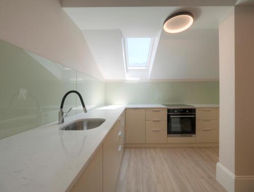 a white kitchen with a sink and a window at CASA AL MARE RESIDENCE in Bečići