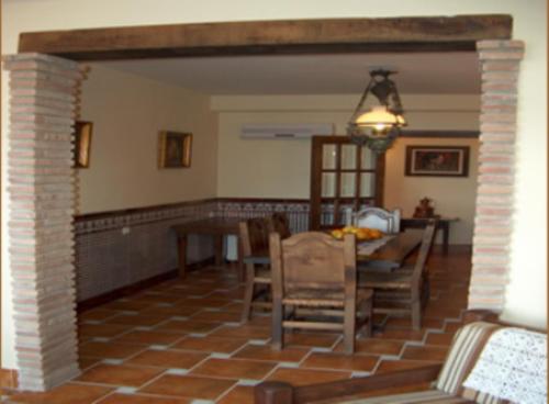 a living room with a table and a dining room at Hotel Los Rebites in Huétor Vega