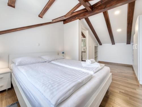 a large white bed in a room with wooden ceilings at Casa Conrad in Opatija