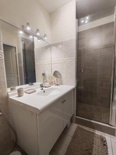 une salle de bain blanche avec un lavabo et une douche dans l'établissement Appartement Domaine Sainte Maxime Park, à Sainte-Maxime