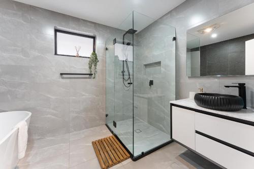 a bathroom with a glass shower and a sink at New, Comfy & Fully Equipped 3BR Home in Kellyville in Glenwood