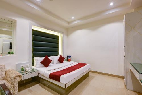 a bedroom with a bed and a chair and a window at Hotel Krishna Deluxe-By RCG Hotels in New Delhi