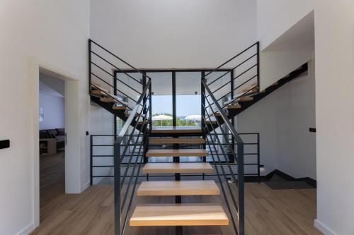 a spiral staircase in a home with white walls and wood floors at Luxury villa with a swimming pool Kastel Stari, Kastela - 24431 in Kastel Stari