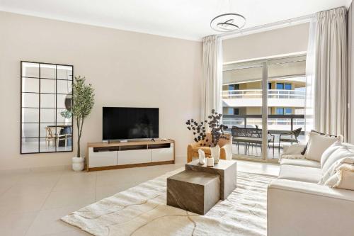 a living room with a couch and a tv at Silkhaus Vacation Homes Ajwan Tower 1BR with Maid room in Saadiyat Island in Abu Dhabi